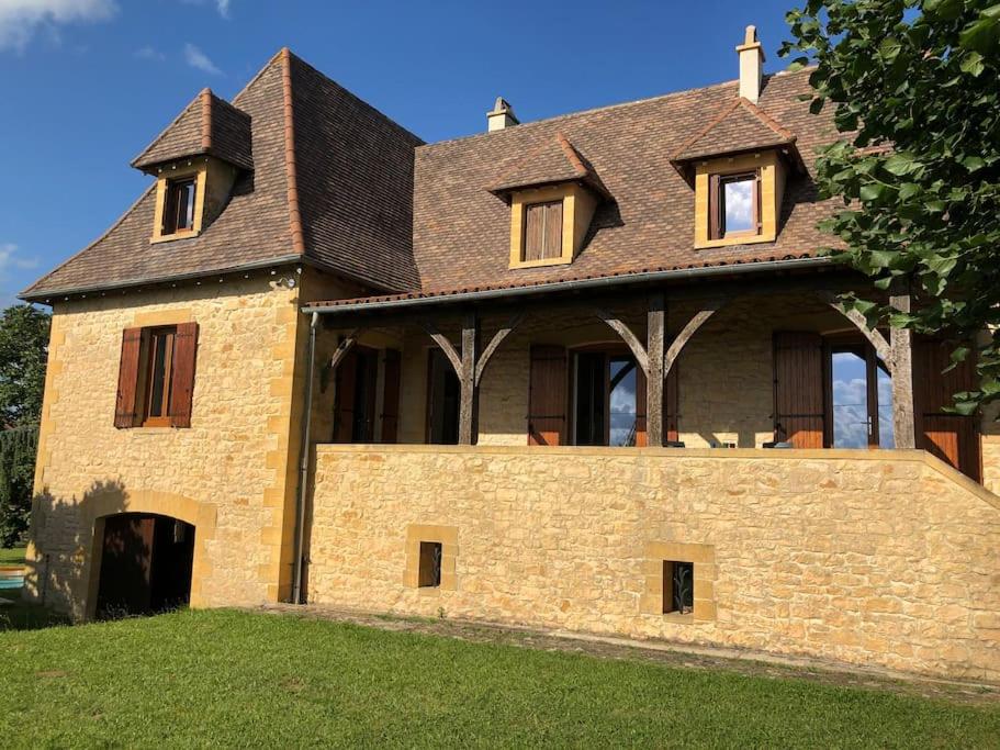 une grande maison en briques avec un toit brun dans l'établissement Grande maison en Périgord à 10 mn de Sarlat, à Marquay
