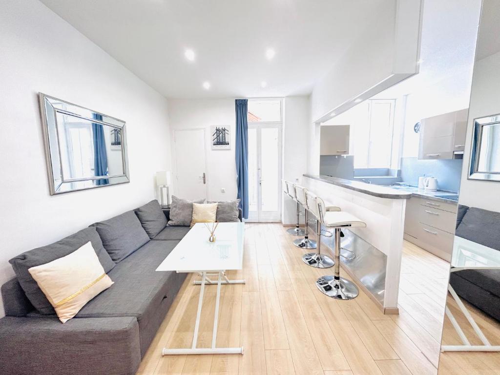 a living room with a couch and a table and a kitchen at 1 Bedroom flat with Balcony Cannes Center Croisette 6ppl in Cannes