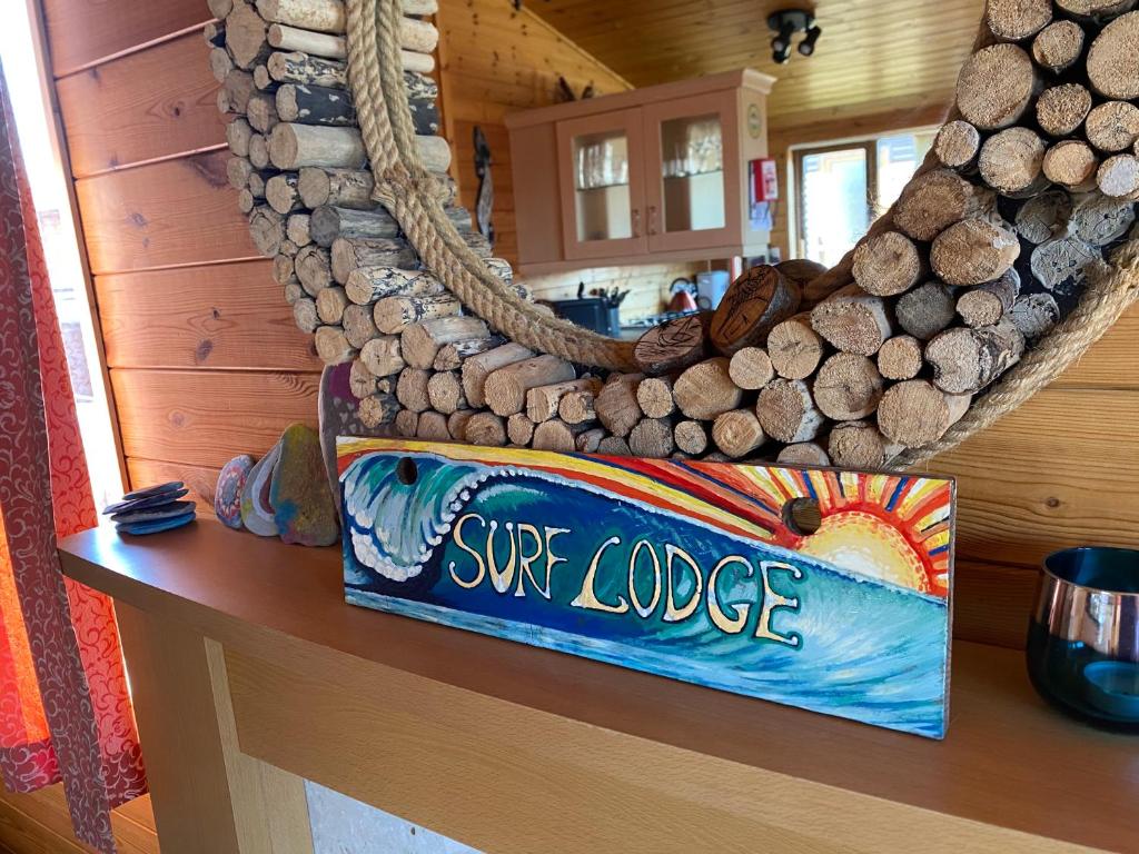a surf lodge sign on a counter in a cabin at Surf Lodge in West Down