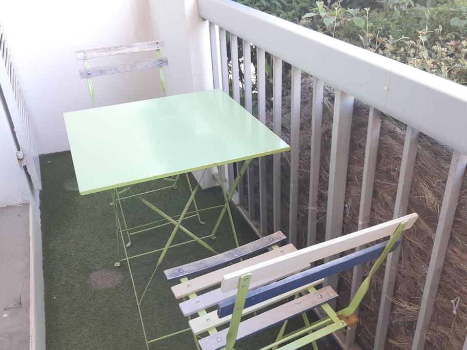 einen grünen Tisch und eine Bank auf dem Balkon in der Unterkunft Joli studio centre de La Baule in La Baule
