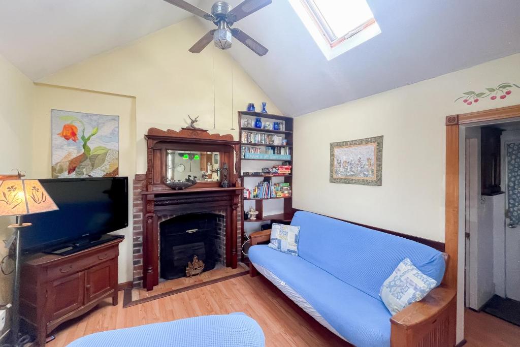 sala de estar con sofá azul y TV en The House on Hobson Lane, en Wells