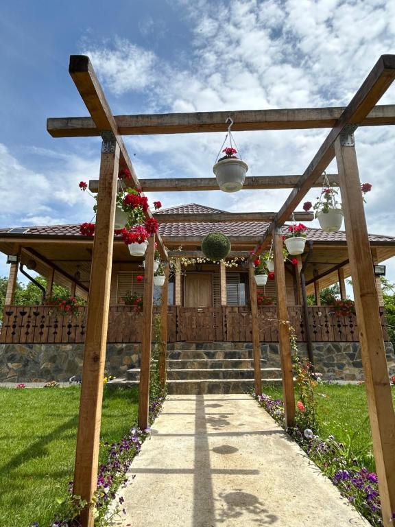 a wooden pergola with potted plants and flowers at Casa Eden Fit in Făget