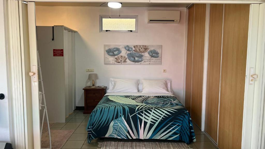 um pequeno quarto com uma cama num quarto em DAMYR PLACE em Faaa