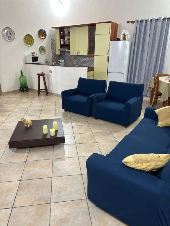 sala de estar con sofás azules y cocina en Panorama, en Lido Signorino