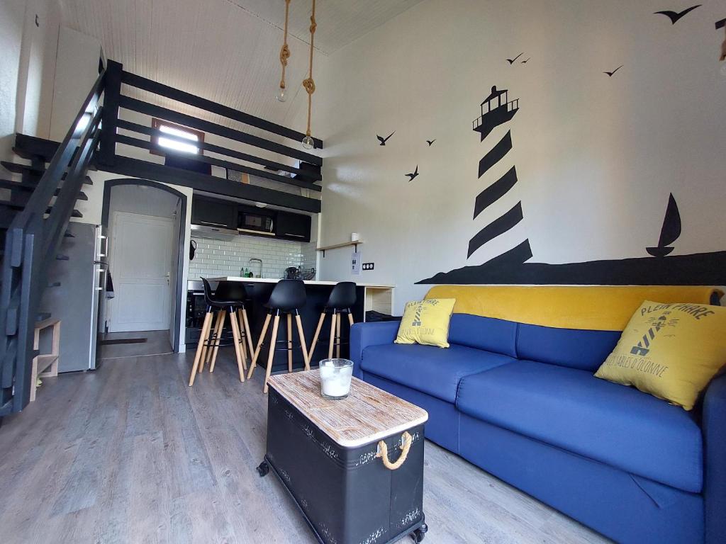 - un salon avec un canapé bleu et un escalier dans l'établissement Maisonnette Les Sables, à Les Sables-dʼOlonne