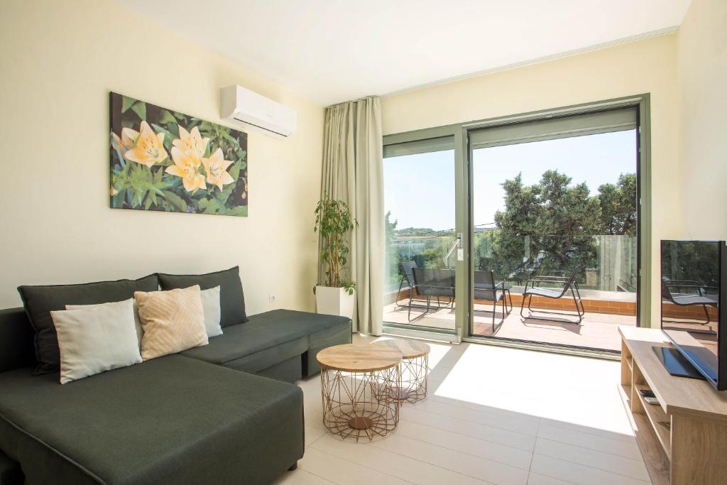 a living room with a couch and a large window at Eden Lily- Luxurious Apartment with Sea View in Rhodes Town