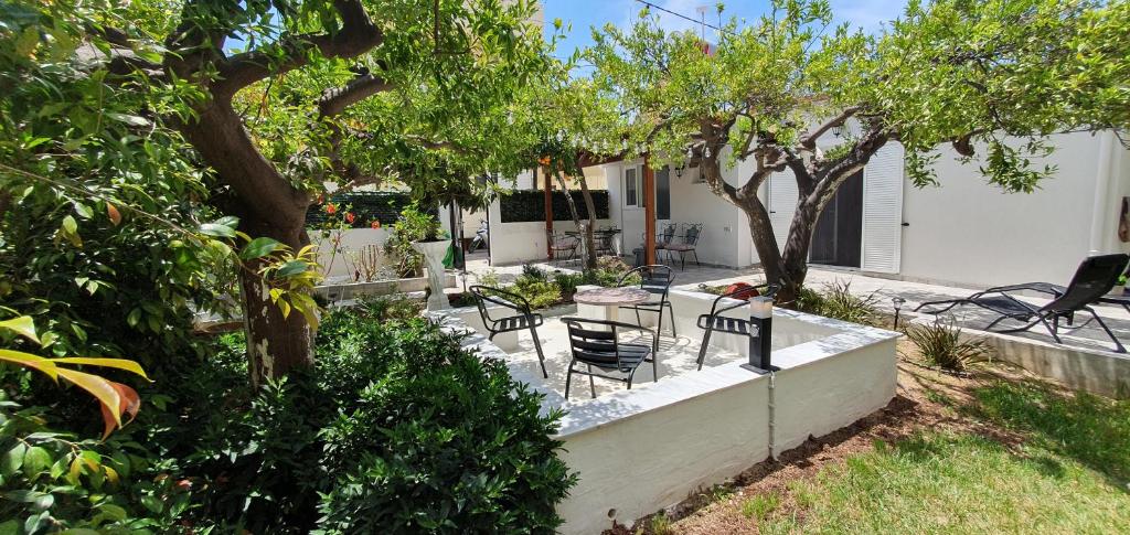 a backyard with a table and chairs and trees at Aeropis Villa, Chania in Chania