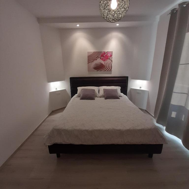 a bedroom with a large bed and two lamps at Apartments Filipovic in Biograd na Moru