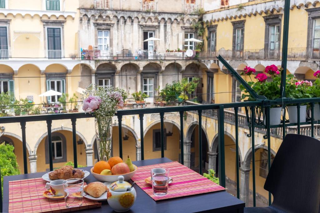 een tafel met een schaal fruit op een balkon bij CloisterVista apartment in Napels
