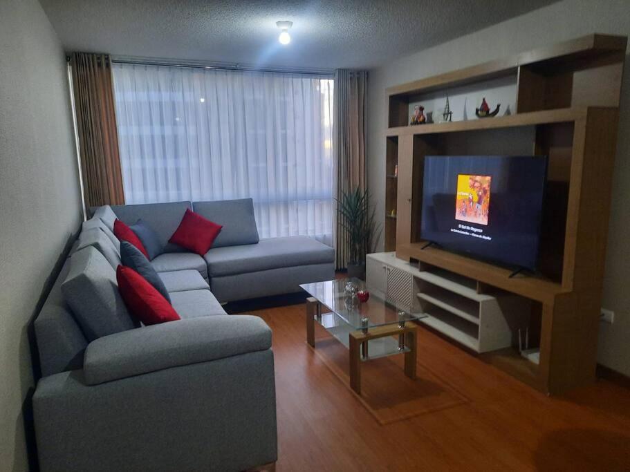 sala de estar con sofá y TV de pantalla plana en Hermoso dpto en condominio residencial en estreno, en Paucarpata