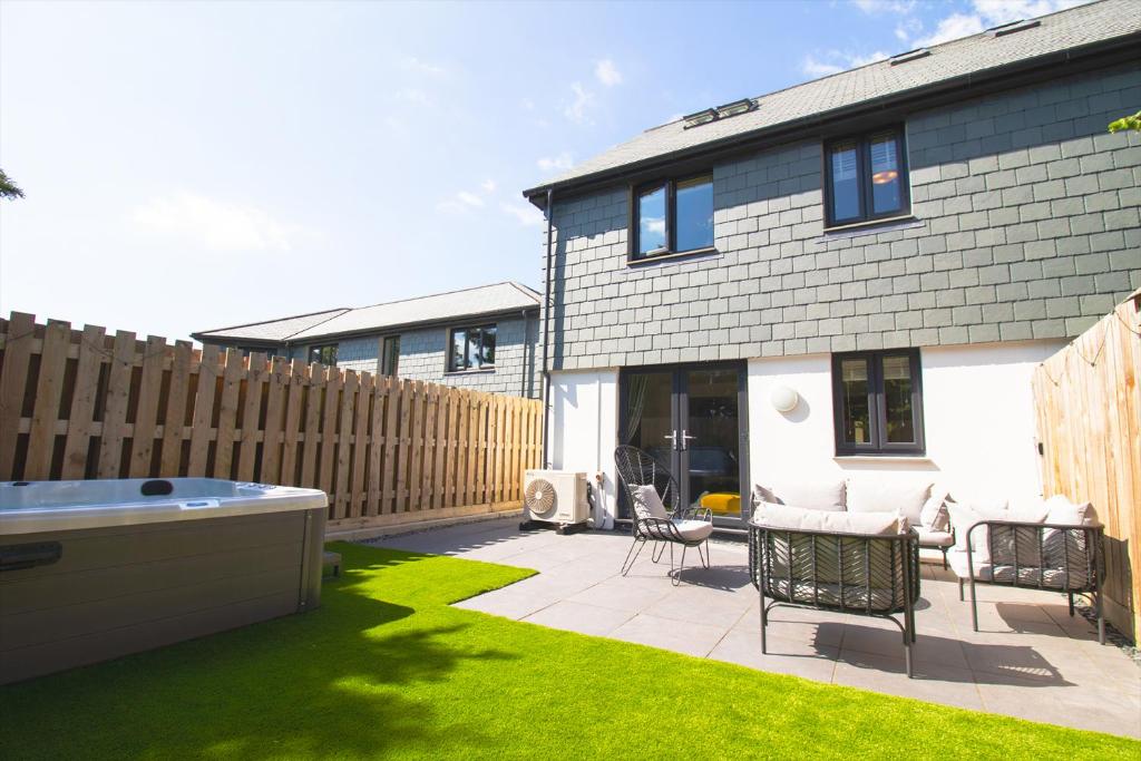 a backyard with a hot tub and a fence at Huckleberry - Premium, Hot Tub, x2 Parking, Farm Shop Next door, Private Cornish Lane in Newquay