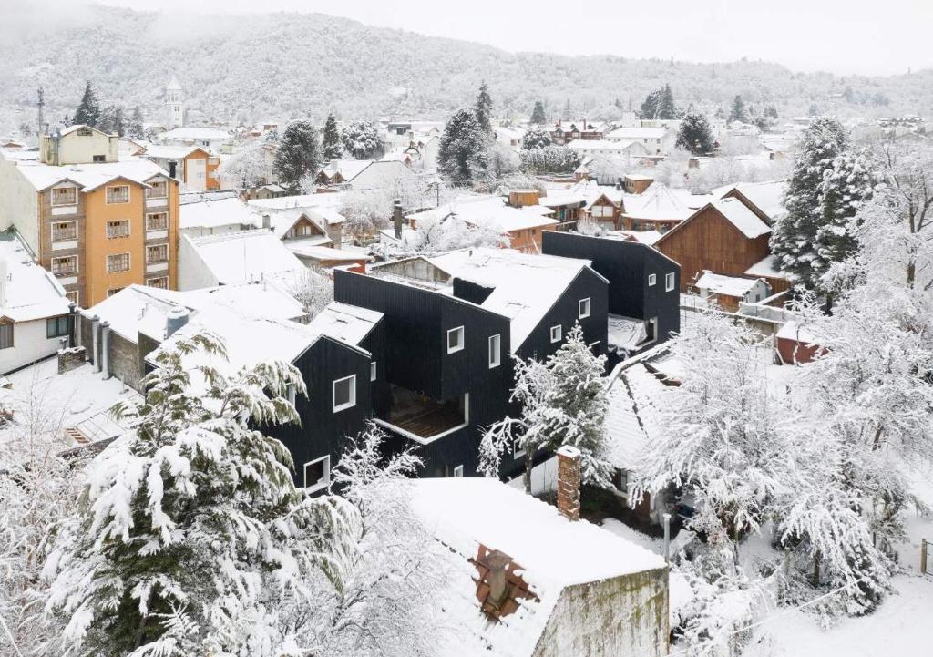 una città ricoperta di neve con case e alberi di Montaña Domesticada a San Martín de los Andes