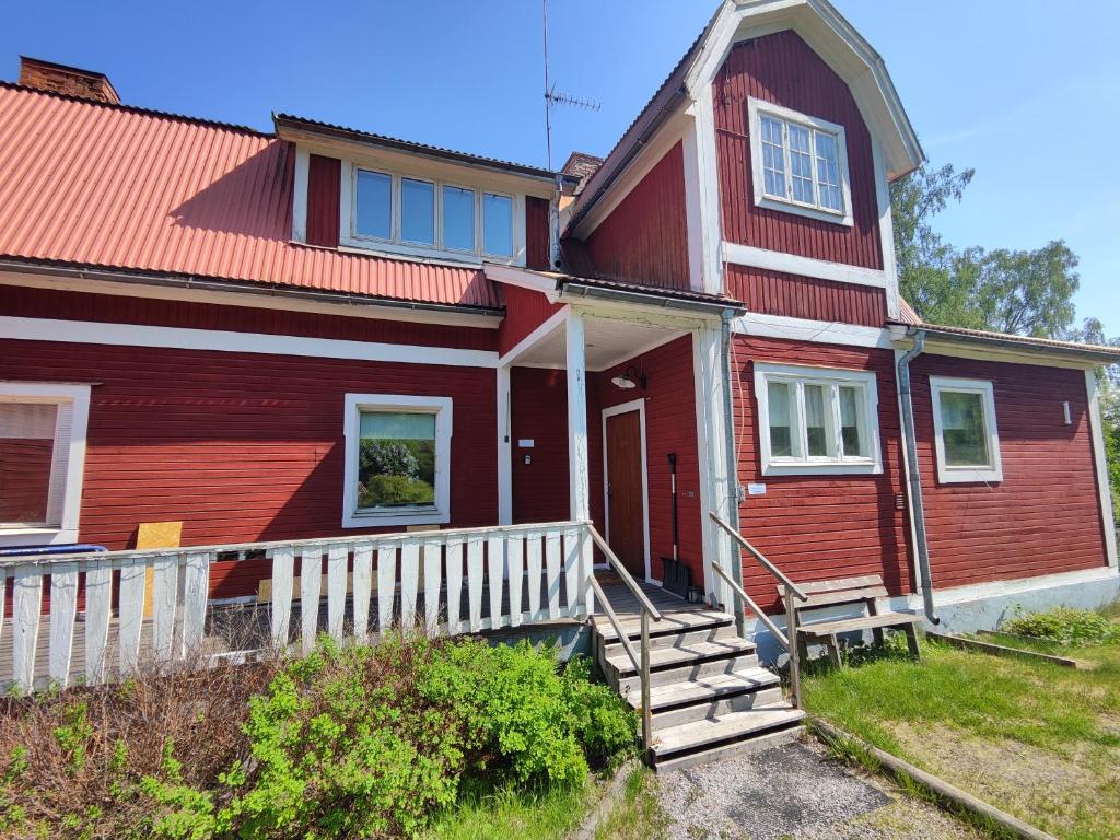 a red house with a white fence in front of it at Living Ludvika in Ludvika