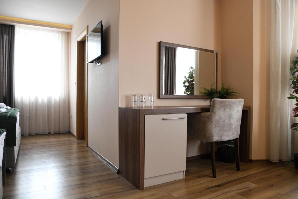 Camera con tavolo da trucco, specchio e sedia. di Hotel Garden a Novi Sad