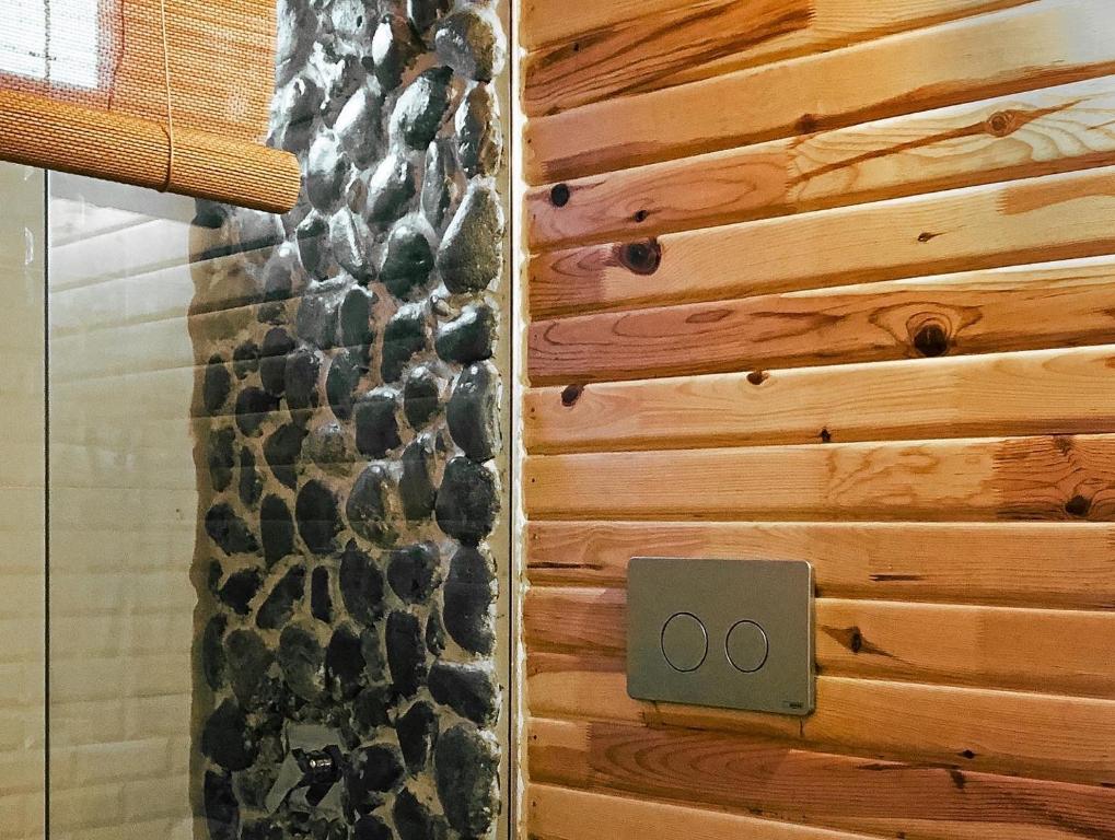 a bathroom with a shower with a wooden wall at Şana Yaşam Köyü 