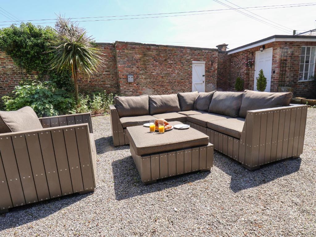 a patio with a couch and a table at The Garden Apartment in Yarm