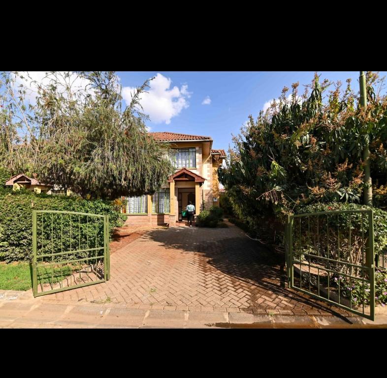 una casa con un cancello di fronte a un cortile di House 469 a Nairobi