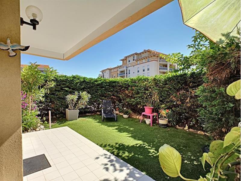 un pequeño patio con césped y un jardín sidx sidx sidx sidx en Bel Appartement Frejus, en Fréjus