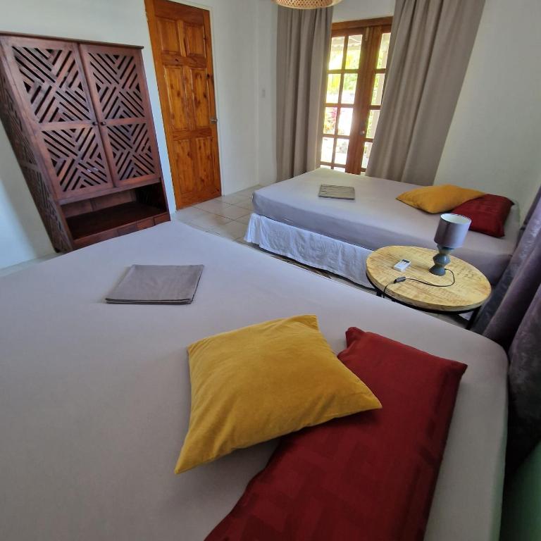 1 dormitorio con 2 camas, sofá y mesa en Nos Soño Stay and Dive, en Westpunt
