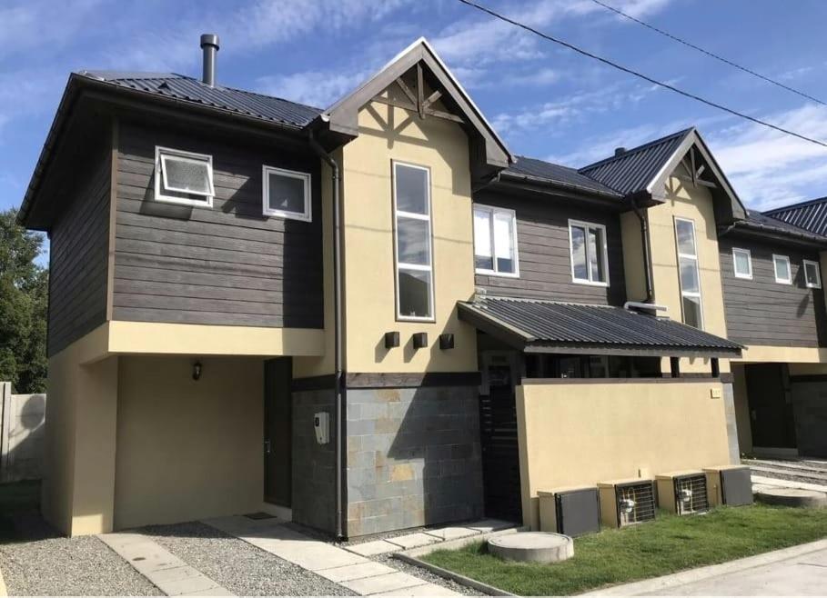 uma casa grande com um telhado preto em Casa Pucón em Pucón