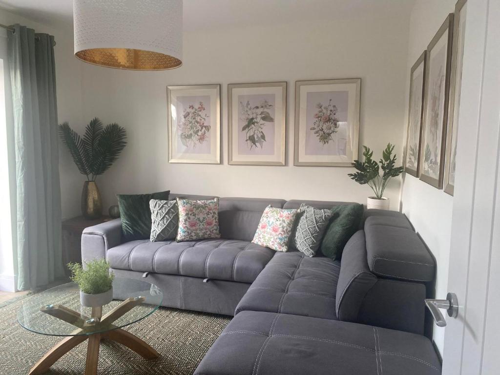 a living room with a blue couch and a table at The Cwtch Pet Friendly Ground Floor Flat Near M4 and Porthcawl in Kenfig Hill