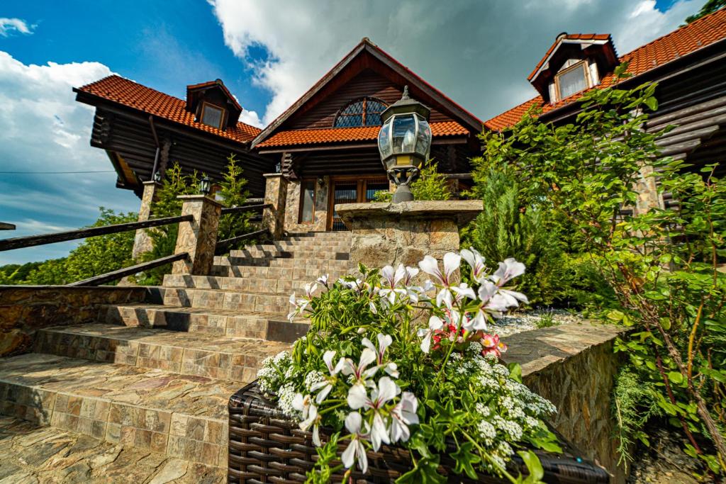 una casa con escaleras y flores delante en Rustic Cottage, en Sibiu