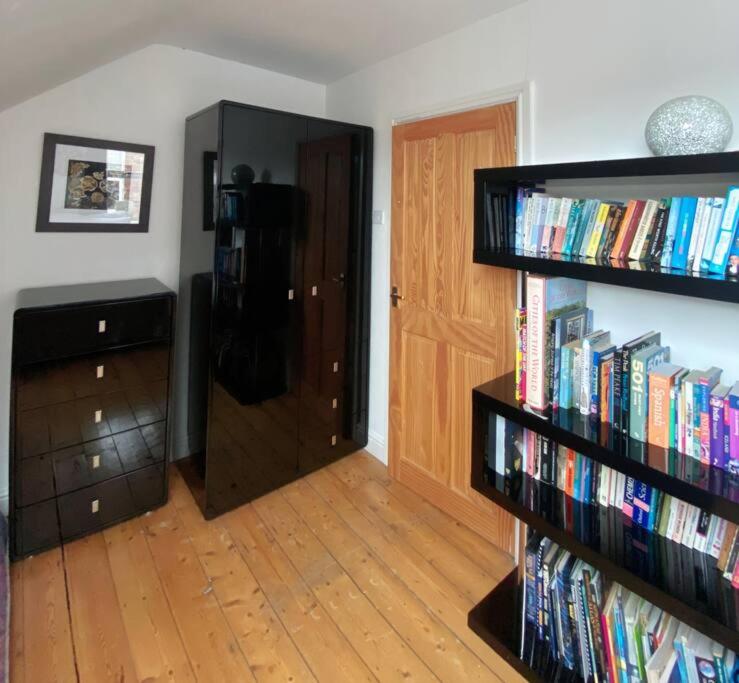 a room with a book shelf filled with books at 3 bed Luxury Victorian Home with Hot Tub in Nottingham