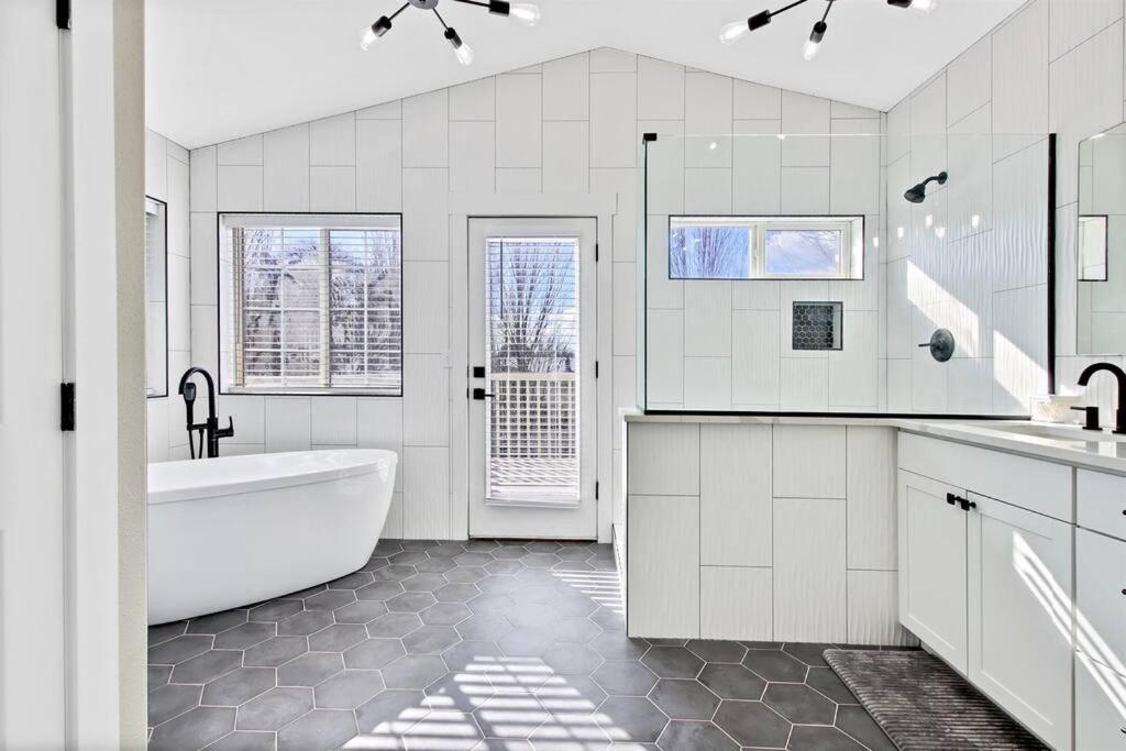 ein weißes Badezimmer mit einer Badewanne und einem Waschbecken in der Unterkunft Modernized Picturesque Lonestar Property with Priv in Nampa
