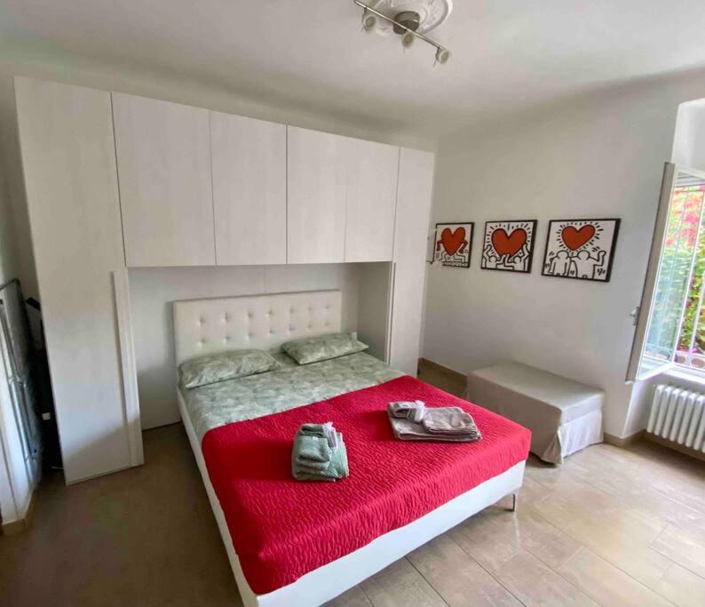 um quarto com uma cama com cobertor vermelho e sapatos em All’ombra delle sophore (011015-LT-2264) em La Spezia