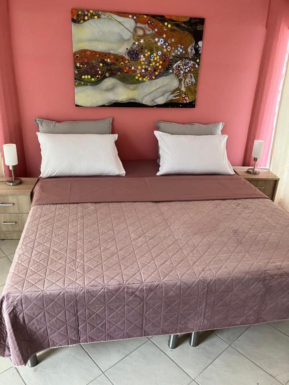 a bedroom with a bed with a pink wall at Fanaria rest 
