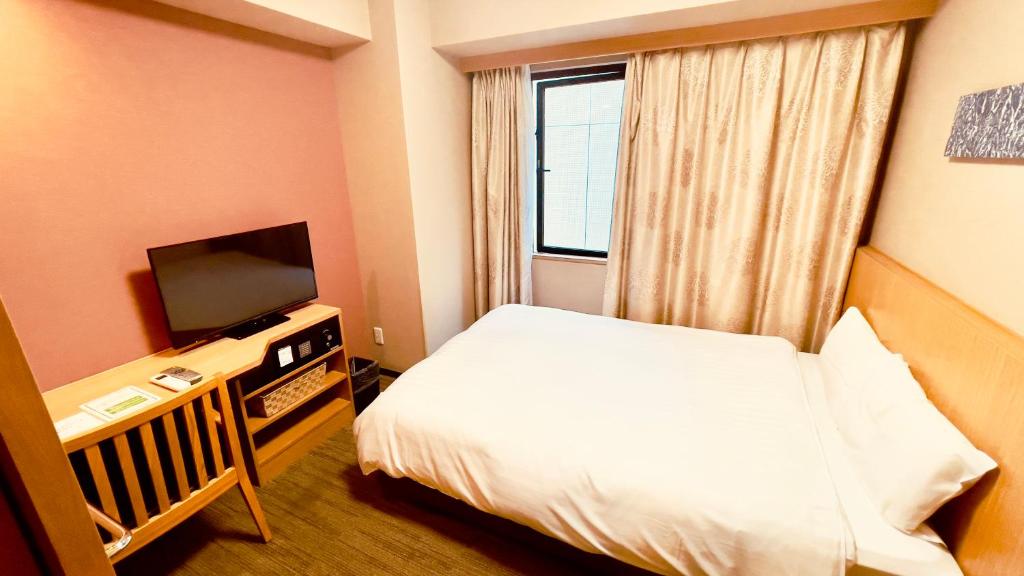 a hotel room with a bed and a television at Dormy Inn Premium Tokyo Kodenmacho in Tokyo