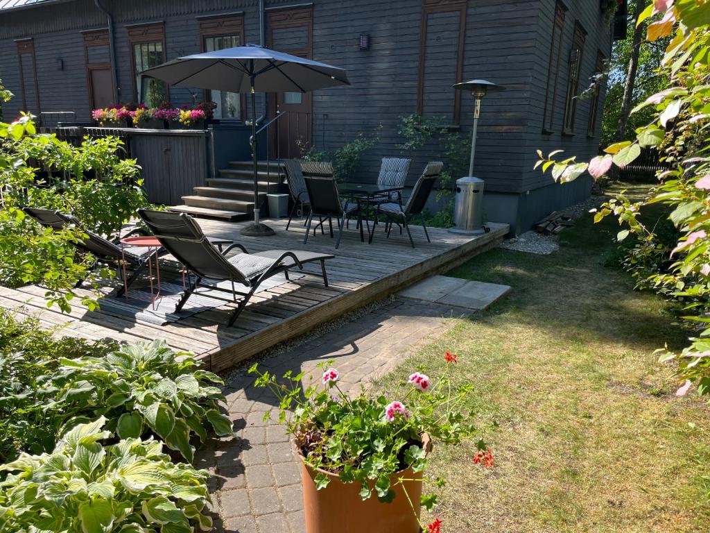 a patio with chairs and an umbrella in a yard at Family house near beach Vecāķi in Rīga