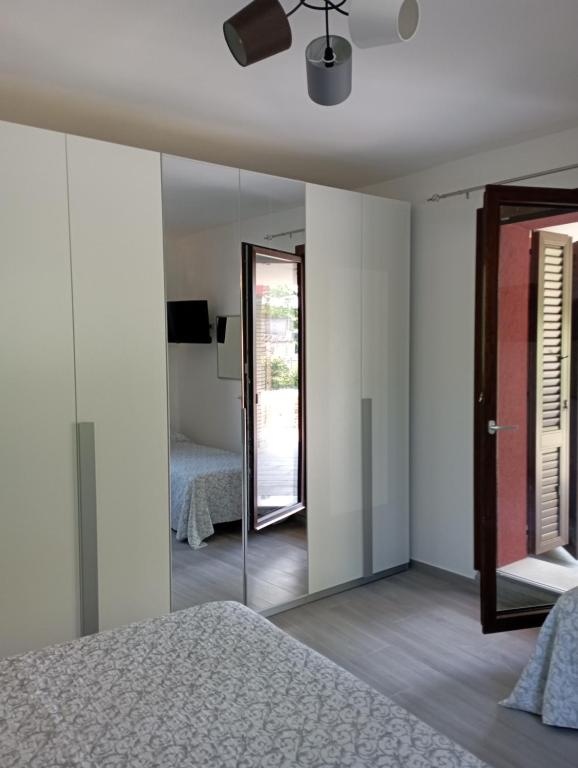1 dormitorio con espejo y 1 cama en B&B Profumo Di Gelsomino, en Mombaroccio