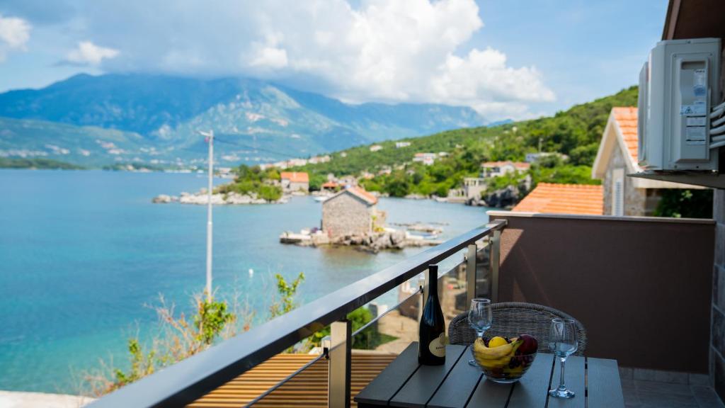 a balcony with a table with a bowl of fruit on it at Family House Bjelila in Tivat