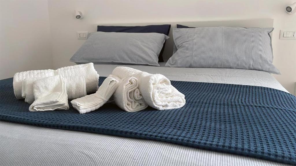een bed met witte handdoeken en kussens erop bij A casa di Ada [127] in Pescara