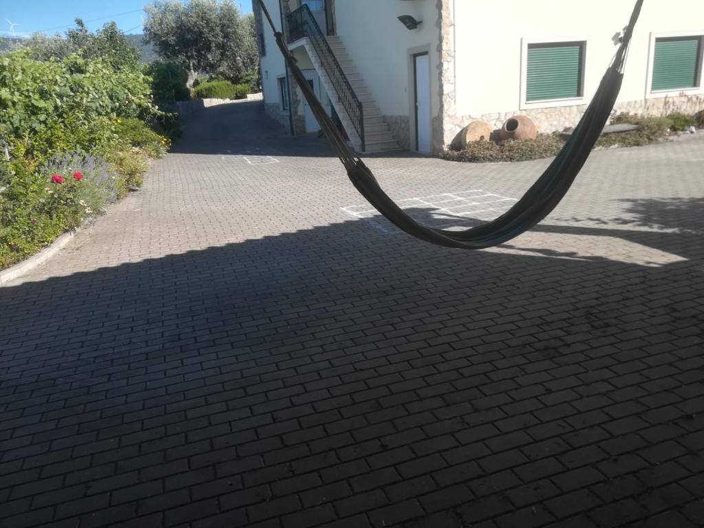 un tuyau est suspendu sur un trottoir en briques dans l'établissement Cantinho Verde, à Sertã