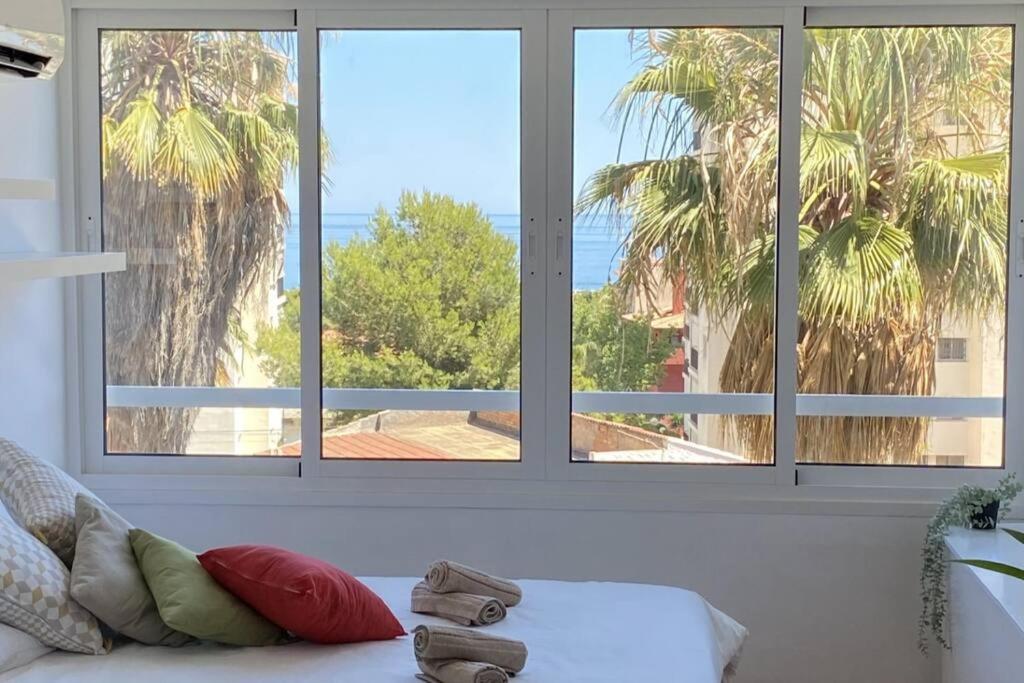 - un salon avec trois fenêtres et un canapé dans l'établissement La ventana de Puerto Marina, à Benalmádena