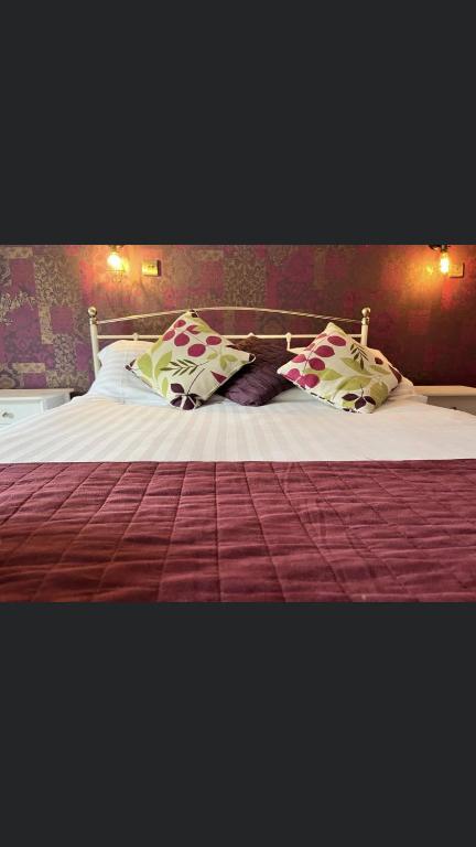 uma cama grande com almofadas em cima em The White Mare em Beckermet