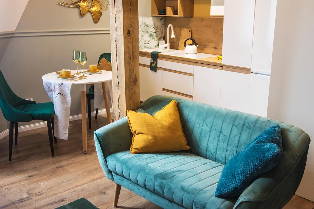 a living room with a blue couch and a table at Apartamenty Paderewskiego 1 in Bydgoszcz
