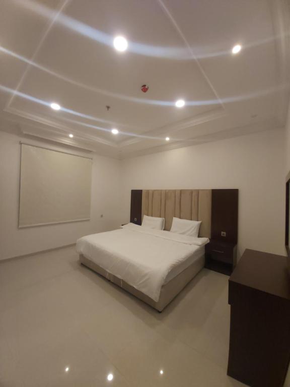 a bedroom with a white bed and a projection screen at شقق فلورنيسا الفندقيه in Taif