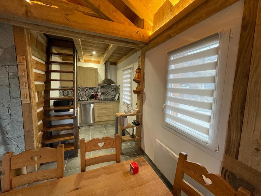 a kitchen with a table and chairs and a window at La cabane de dany in La Bresse