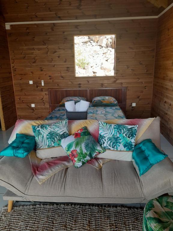 um quarto com uma cama com almofadas em LES HAUTS DE L'ANSE em Bouillante