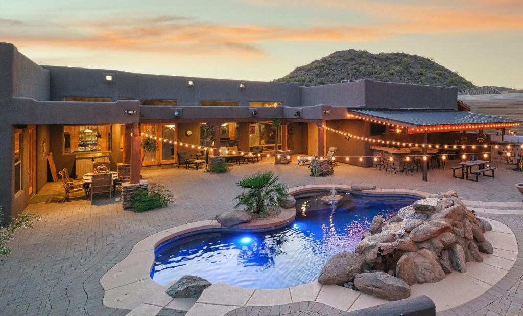 a large house with a swimming pool in the yard at Quail Mountain Desert Resort: Heated Pool, Mt Vews, all BR's King & TV's, Hiking in Mesa