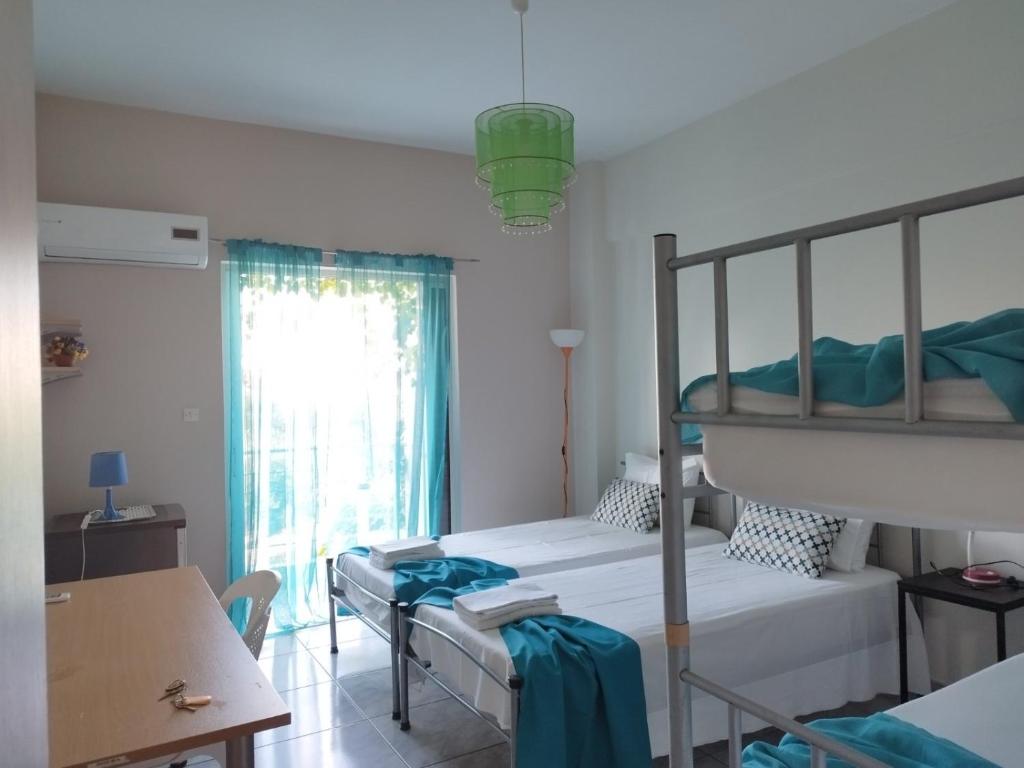 a bedroom with two bunk beds and a table at Vacations in Patra Rooms in Patra