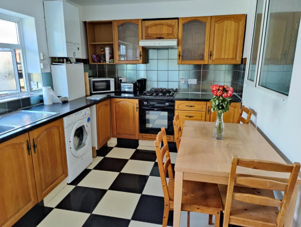 a kitchen with a table with a vase of flowers on it at Beautiful and homely accommodation, Archway in Islington near Camden town in London