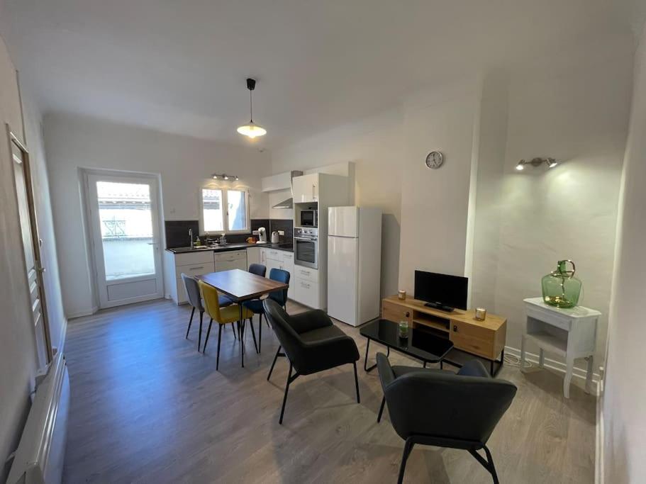een woonkamer met een tafel en stoelen en een keuken bij Appartement+Terrasse en Provence dans le Luberon in Apt