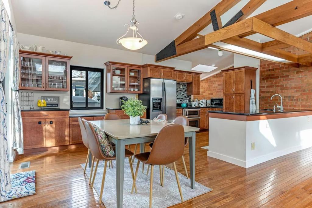 Una cocina con gabinetes de madera y una mesa con sillas. en Spacious - High Ceilings - 4 Min to Beaver Creek, en Avon