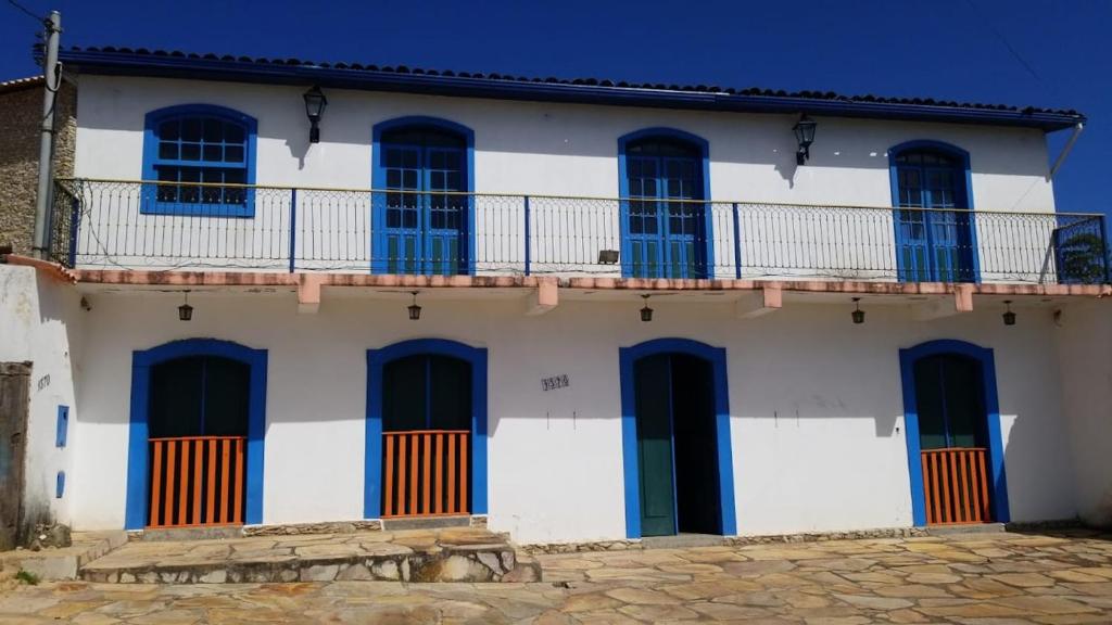 un edificio blanco con puertas y ventanas azules en Solar Maria Gomes - Lavras Novas MG, en Lavras Novas
