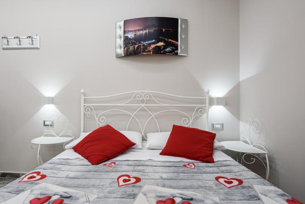 una camera con un letto con due cuscini rossi di Elite del Centro Storico a Napoli