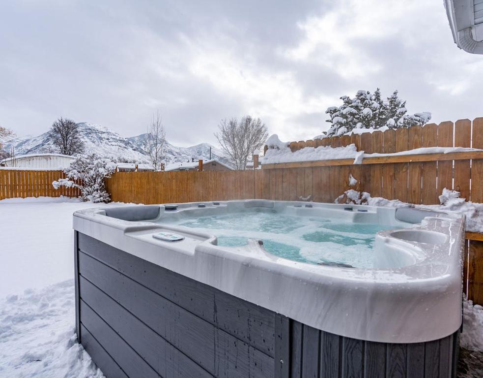 a hot tub covered in snow in a backyard at Modern home near UVU and BYU with hot tub and mountain views in Orem